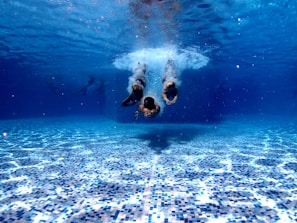 three person diving on water