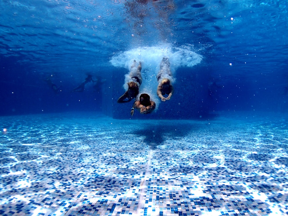 three person diving on water