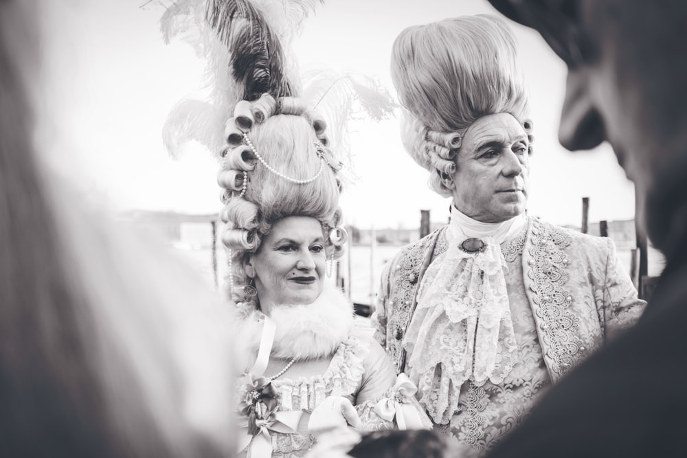 Schwarz-Weiß-Fotografie von Mann und Frau im Kostüm