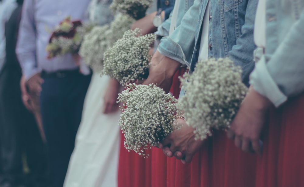 people holding a bouquet of baby's breath flower
