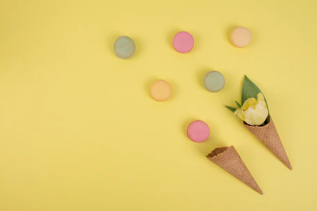 A vibrant flat lay of colorful scoop packages arranged on a soft pink background