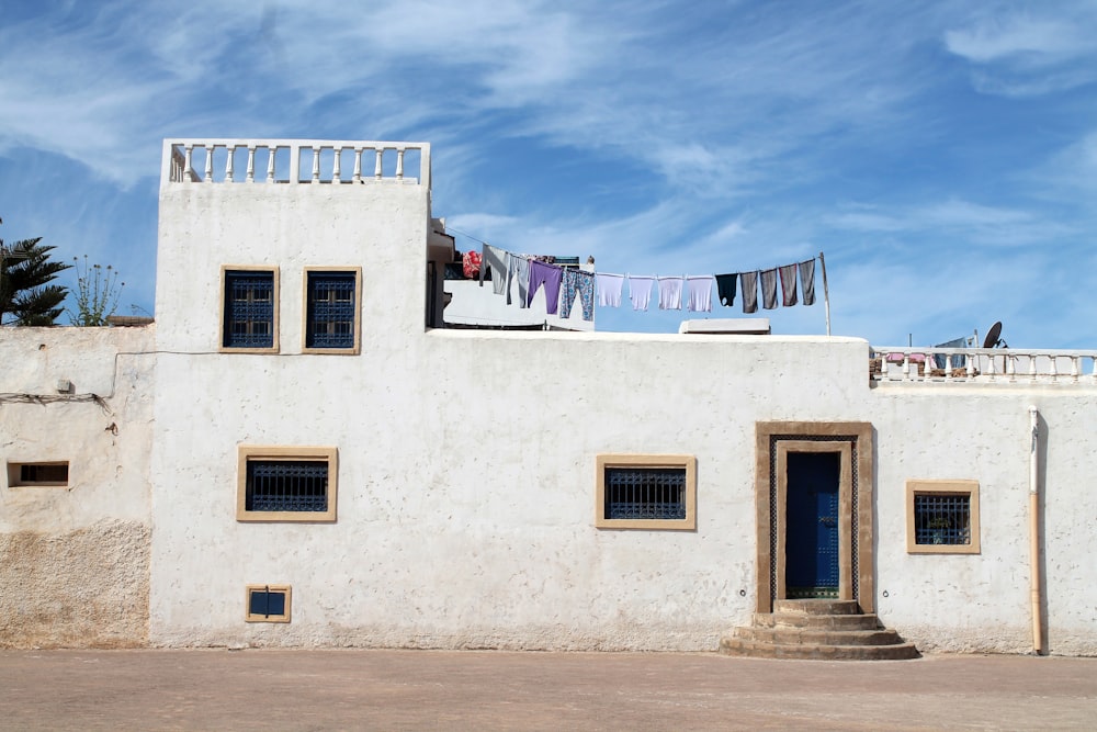 Maison en béton blanc et gris sous ciel bleu