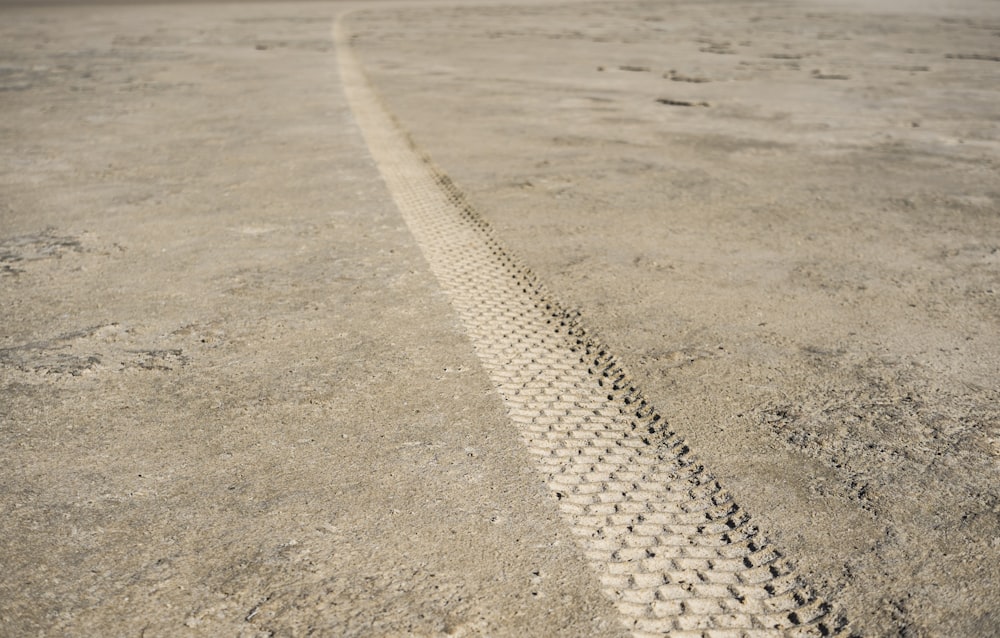 Fotografía de primer plano de la impresión del neumático de la pista en el suelo