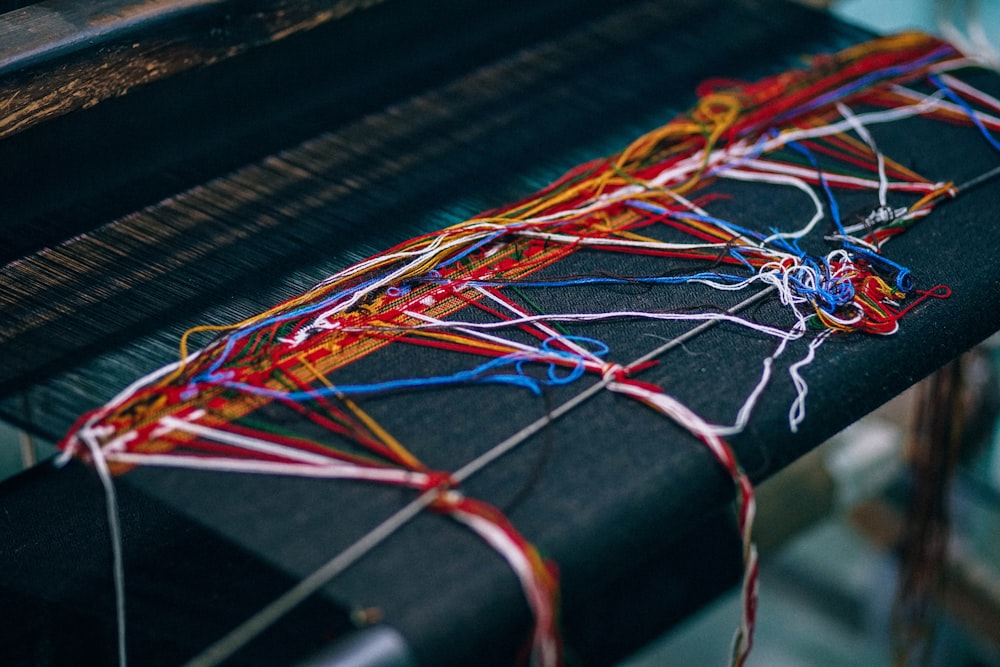 Red white and blue sewing thread on a wooden desk at a factory