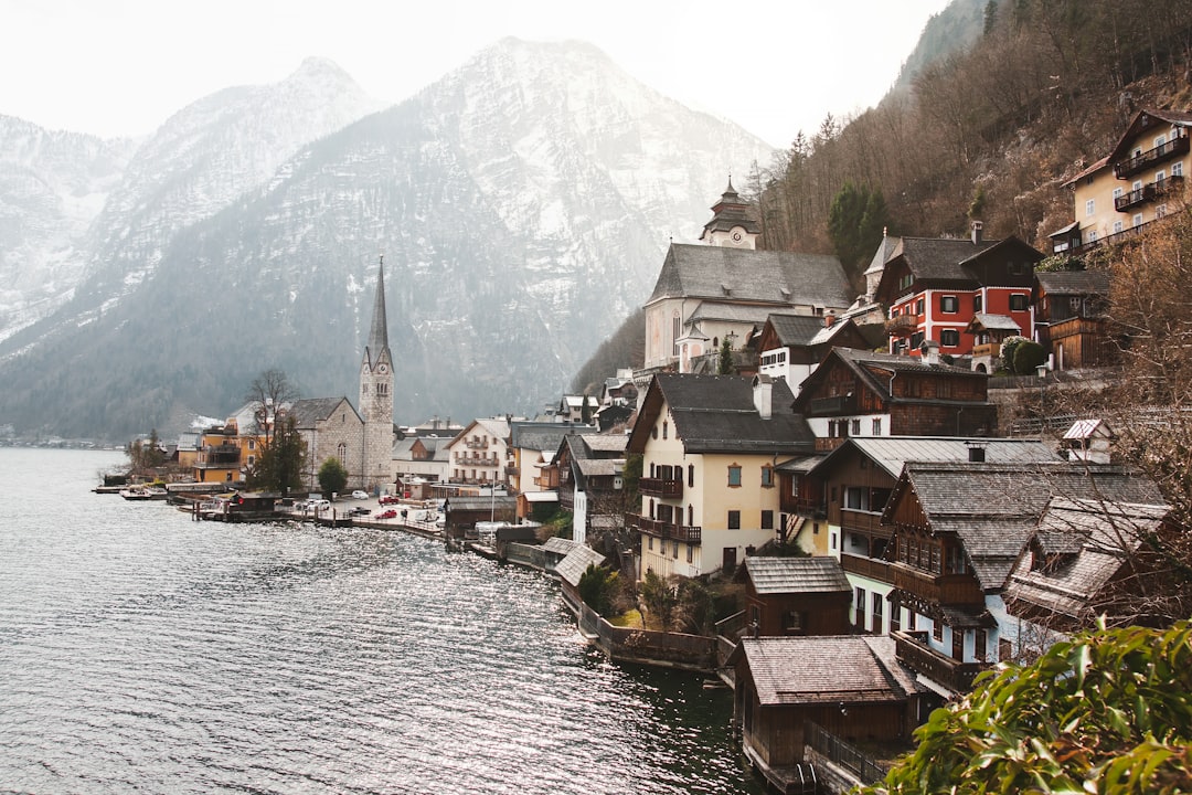 white concrete church near houses beside body of water