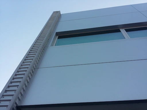 Modern architectural office building exterior with navy and stone gray accents.