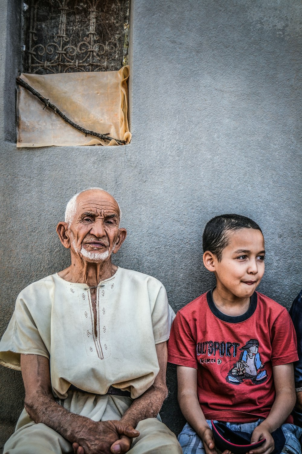 boy sitting next to a man