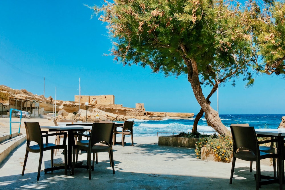 brown wooden table and chairs on beach during daytime