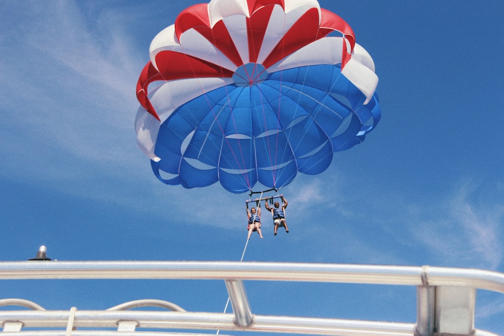 zwei Personen beim Gleitschirmfliegen mit dem Boot