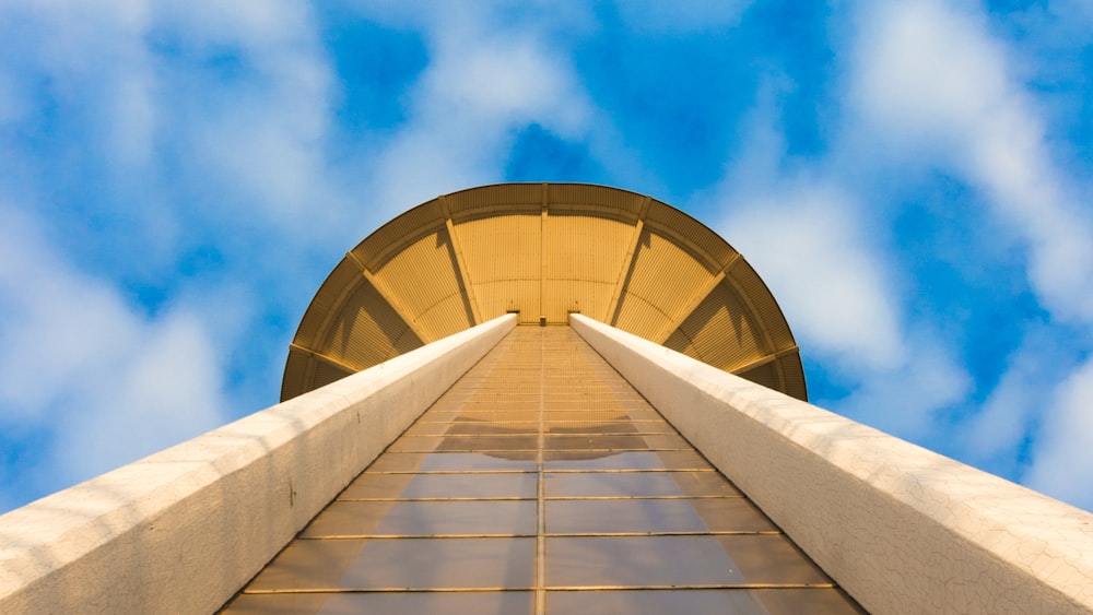 worm's eye view photography of tower under cloudy sky during daytime