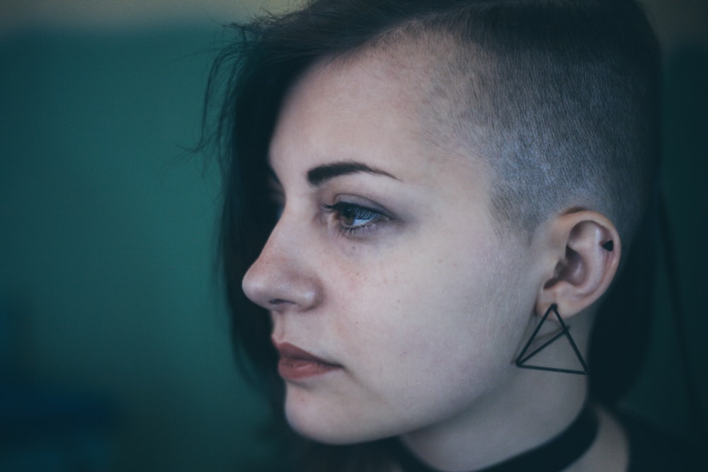 Woman with an edgy shaved haircut looks sad and defeated