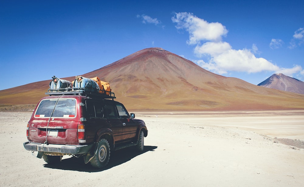 red SUV facing mountain