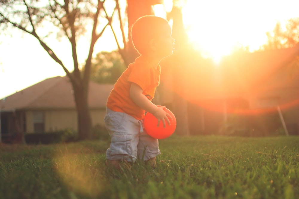 chico sosteniendo globo naranja