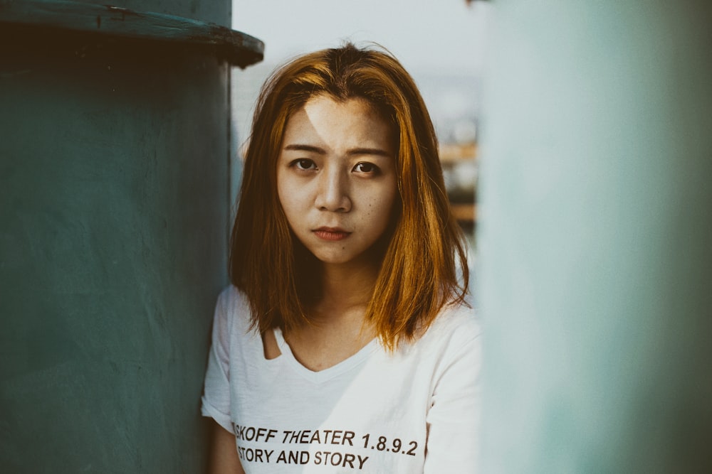 woman wearing white top near metal case