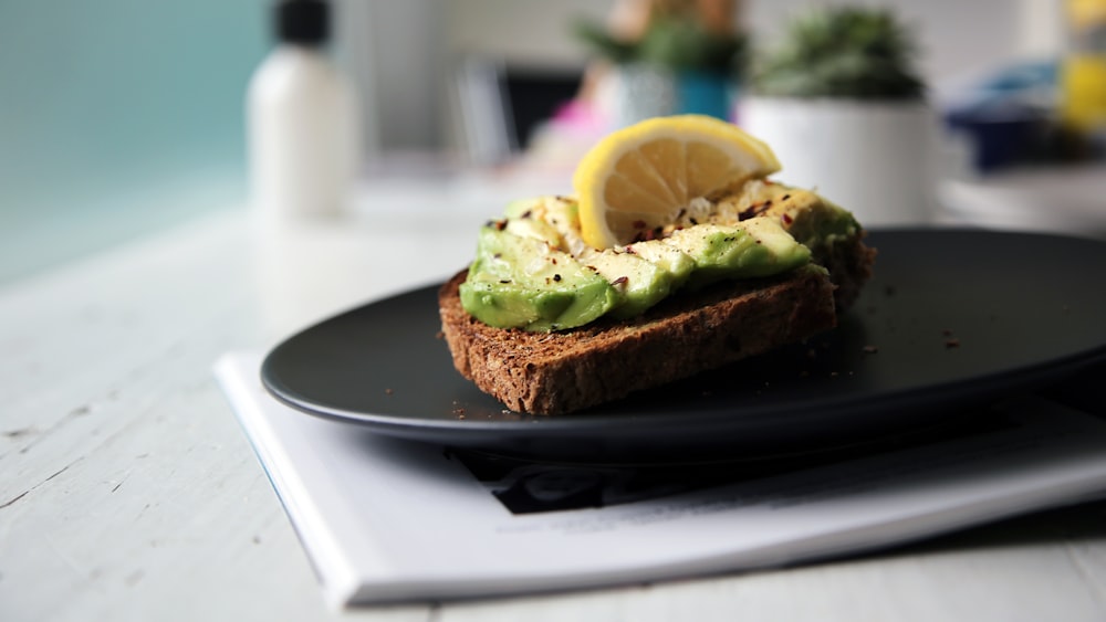 brown bread with sliced avocado and lemon on top
