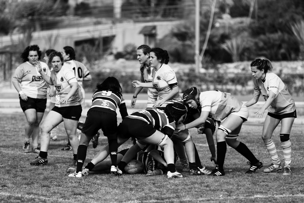 Fotografía en escala de grises de mujeres jugando al fútbol en el campo