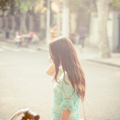 A model walking down a sunlit street wearing a flowing dress from Kristien LLC.