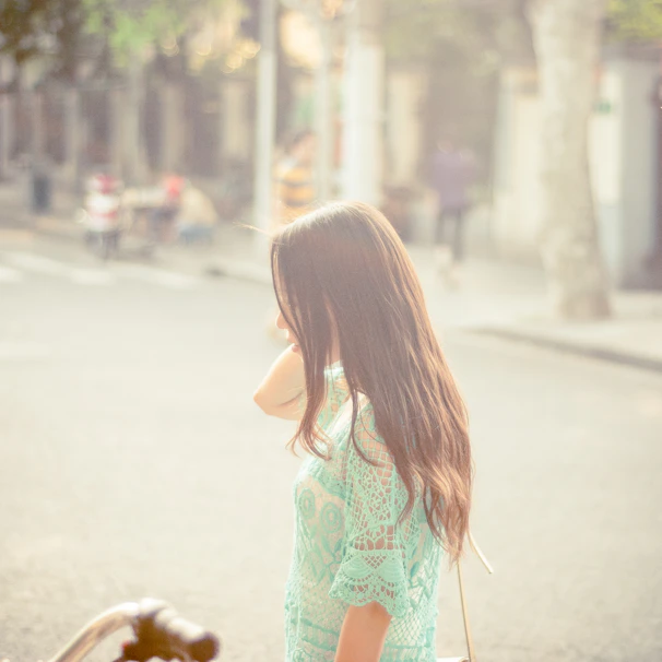 Model wearing a flowing dress in warm sunlight on a city street