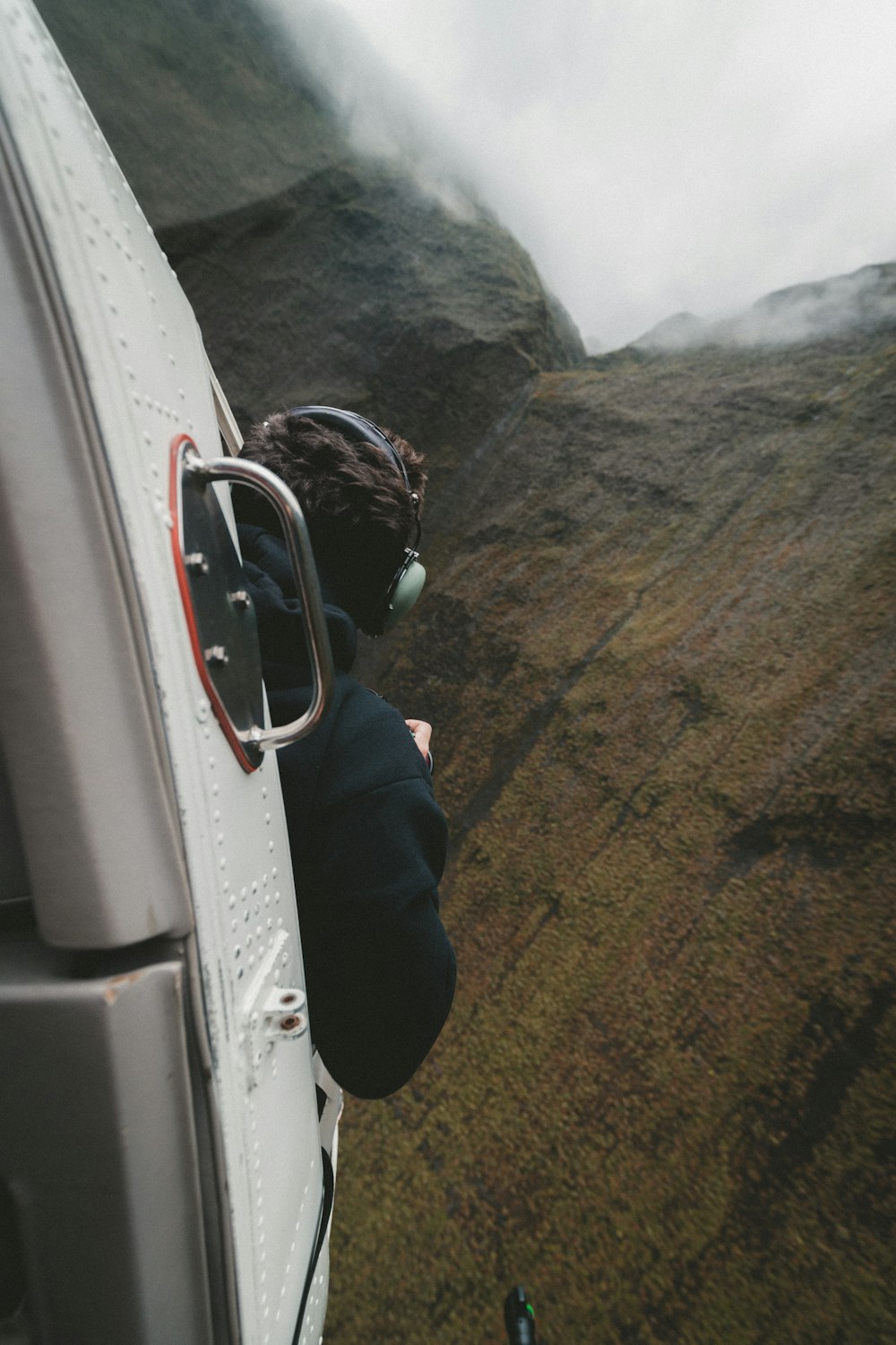 hombre que viaja en avión mirando a la montaña