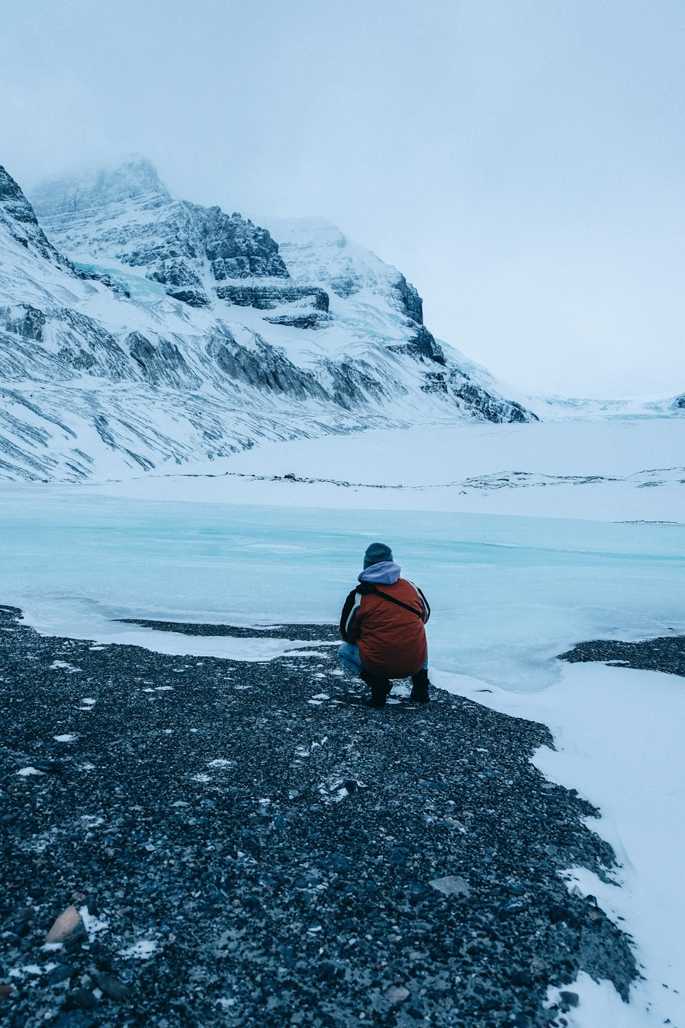 person siting facing mountain