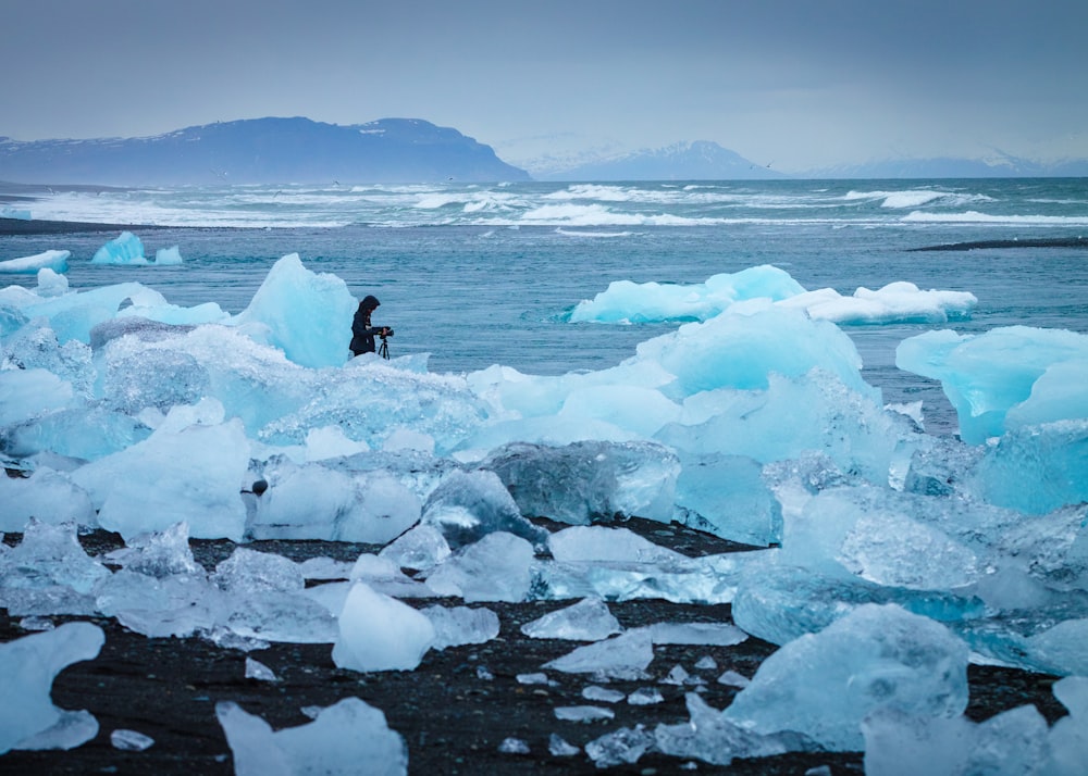 man standing in middle of ice burg