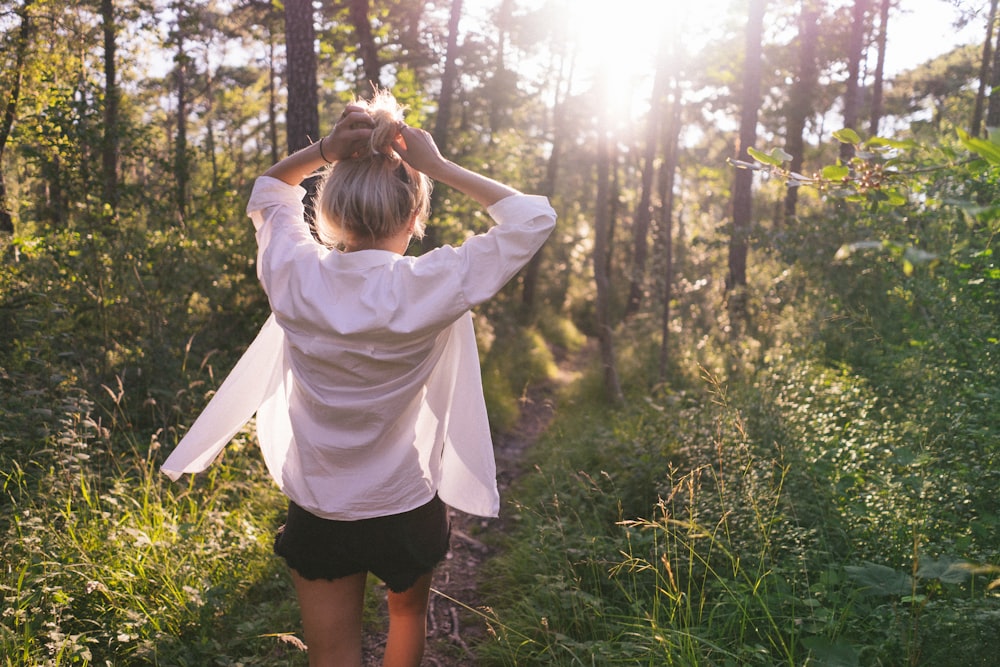 Mujer de pie en el bosque durante el día