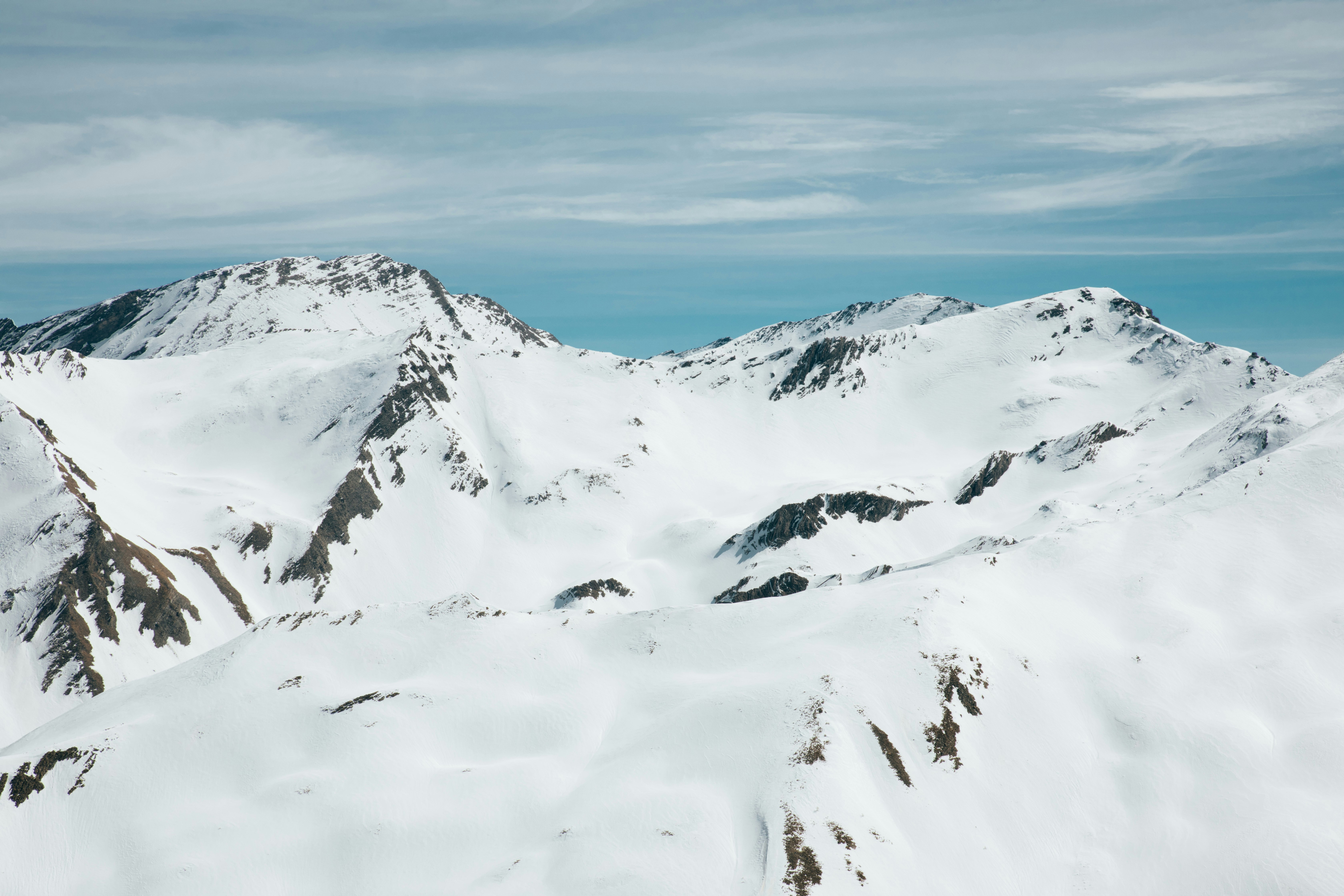 mountain covered by snow under blue sky