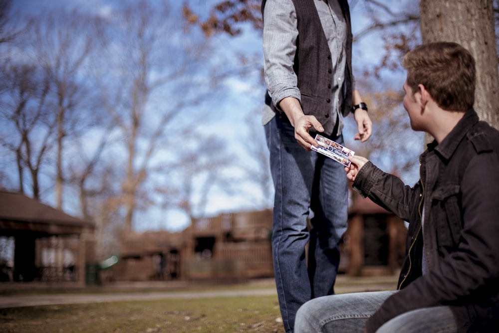 person giving something to man