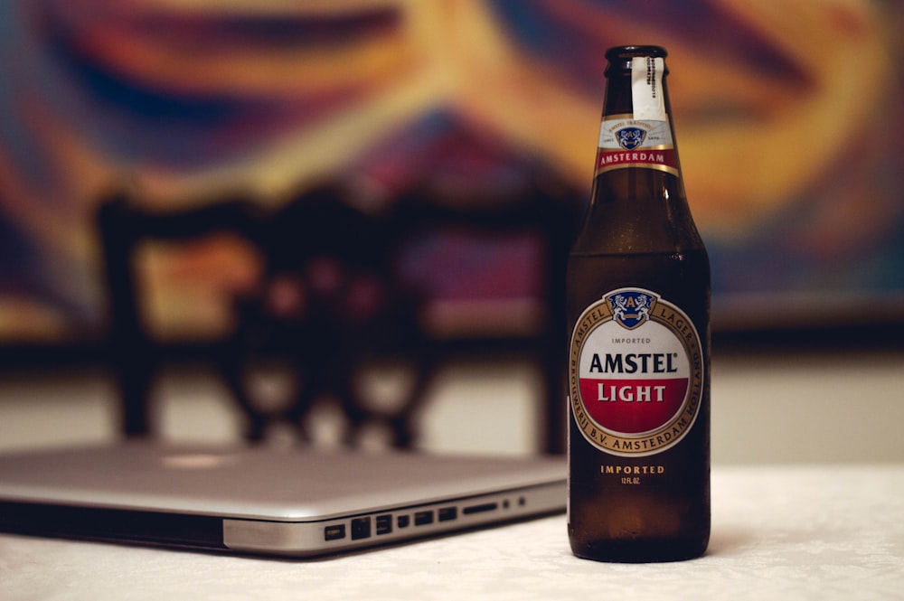Amstel Light beer bottle near laptop computer