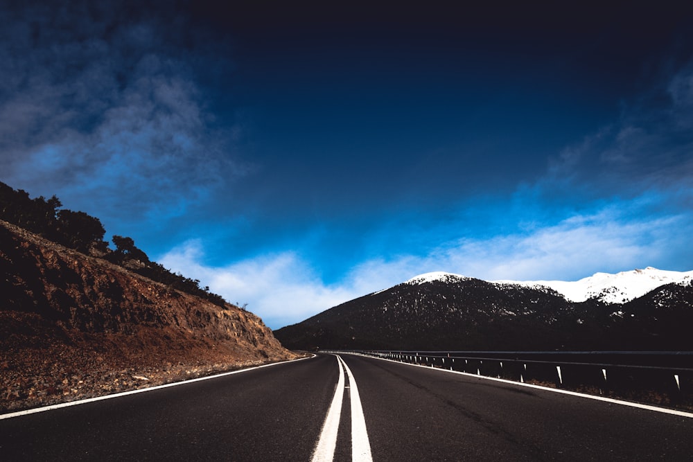 road near mountain under blue sky