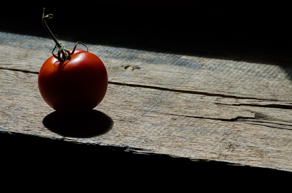 red tomato on brown wooden table