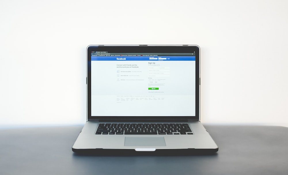 foto a fuoco superficiale del computer portatile grigio su superficie nera