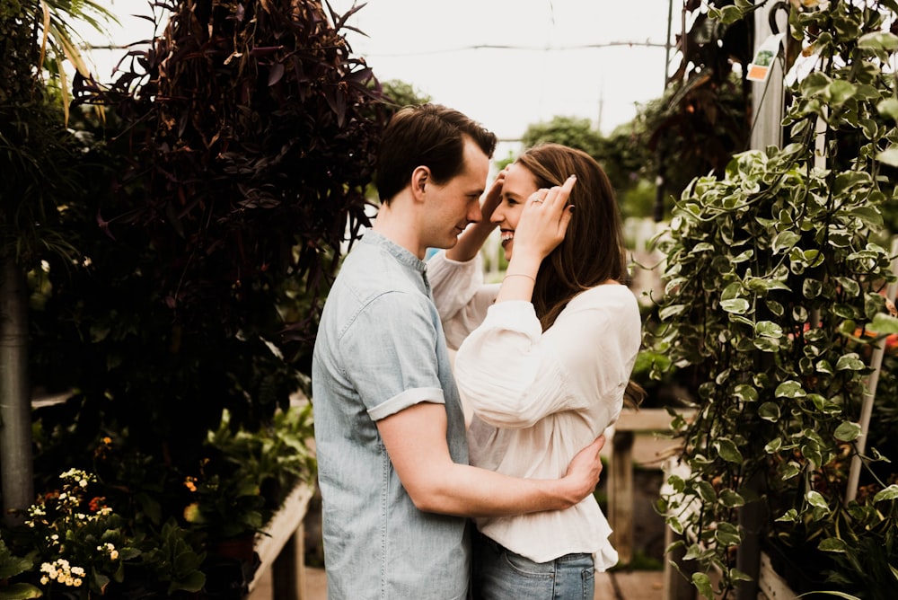 man holding waist of woman surrounded plants