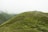 Rolling green hills under a cloudy sky with a small group walking along a winding path during a retreat.