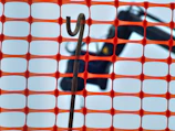 Close-up of a steelguard galvanized crowd control barrier with interlocking hooks on a construction site.