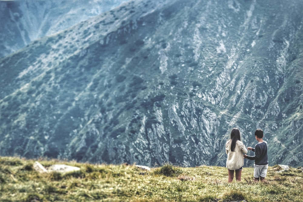 two people standing in front of mountains