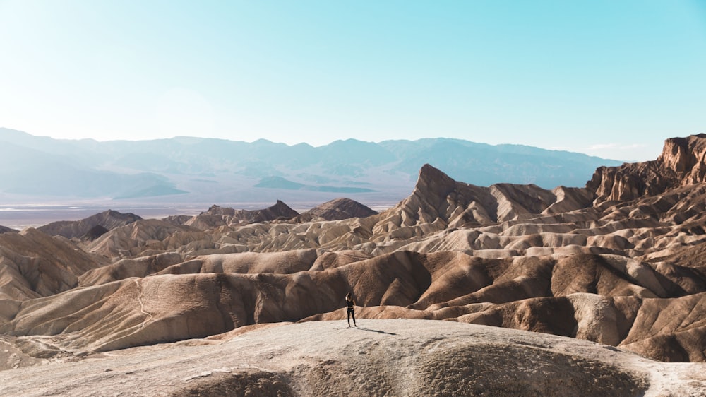 person standing on top of brown hill