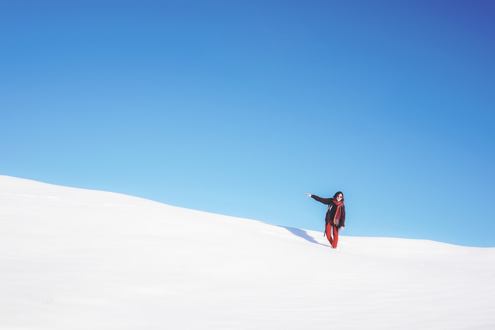 昼間の白い雪原に立つ女性