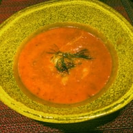 A wholesome homemade soup steaming in a rustic ceramic bowl.