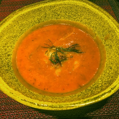 A close-up of a steaming bowl of creamy tomato soup.