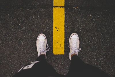Trainers on yellow street lines