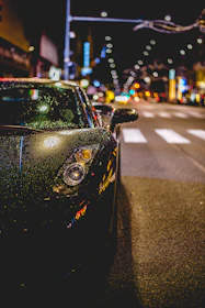 A sleek luxury car gleaming under city lights, ready for a night out.