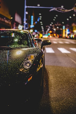 A sleek car wrapped in vibrant protective film parked on a city street.