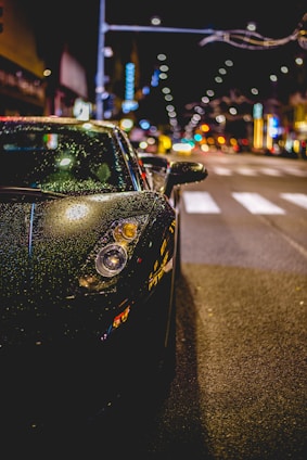 A sleek luxury car gleaming under Toronto’s city lights after a meticulous detailing service.