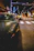 A sleek black luxury European car parked under city lights at night.