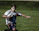 A smiling young rugby player in a 49er rugby jersey holding a ball on a sunny field.