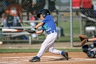 Young player wearing protective gear, ready to face a fast delivery under bright stadium lights.