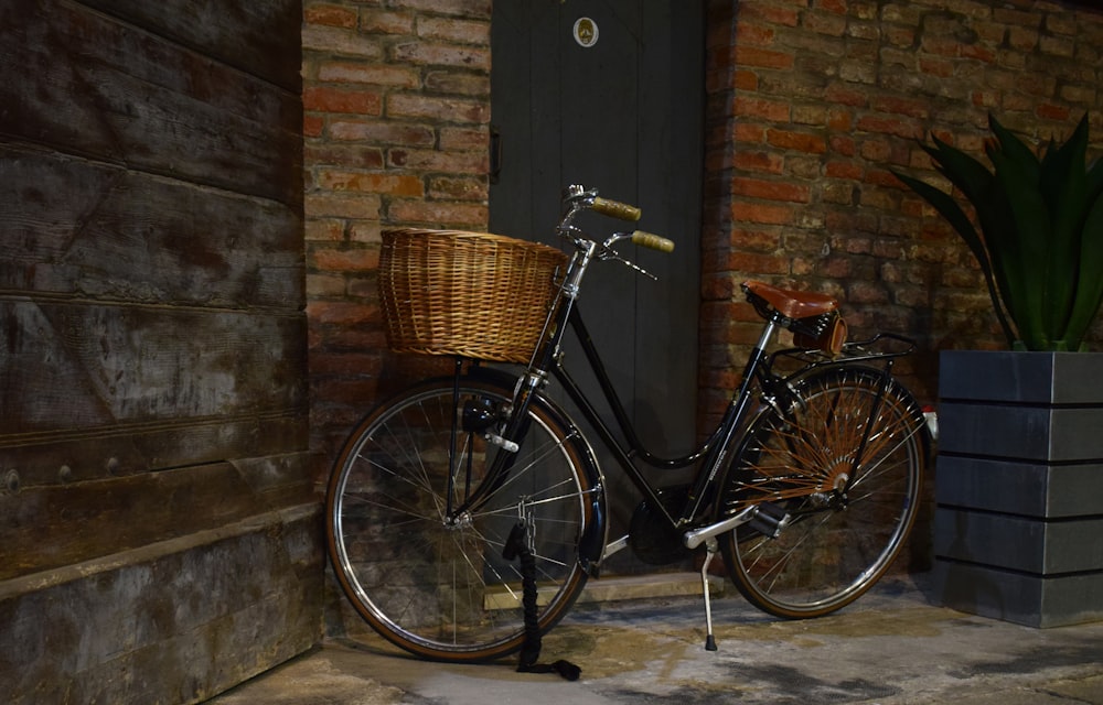 black city bike beside brown brick wall