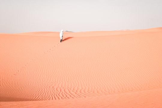 person walking on desert during daytime in Erg Chebbi Morocco