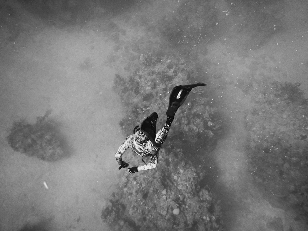 grayscale photo of man about to dive on body of water